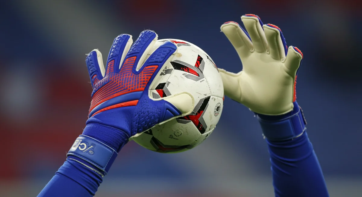 Close-up of US goalkeeper's gloved hands catching a soccer ball