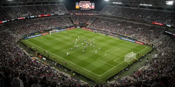 Intense midfield clash during a 2025 MLS Eastern Conference match under stadium lights.