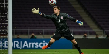 Dynamic US goalkeeper making a crucial save in a professional soccer match